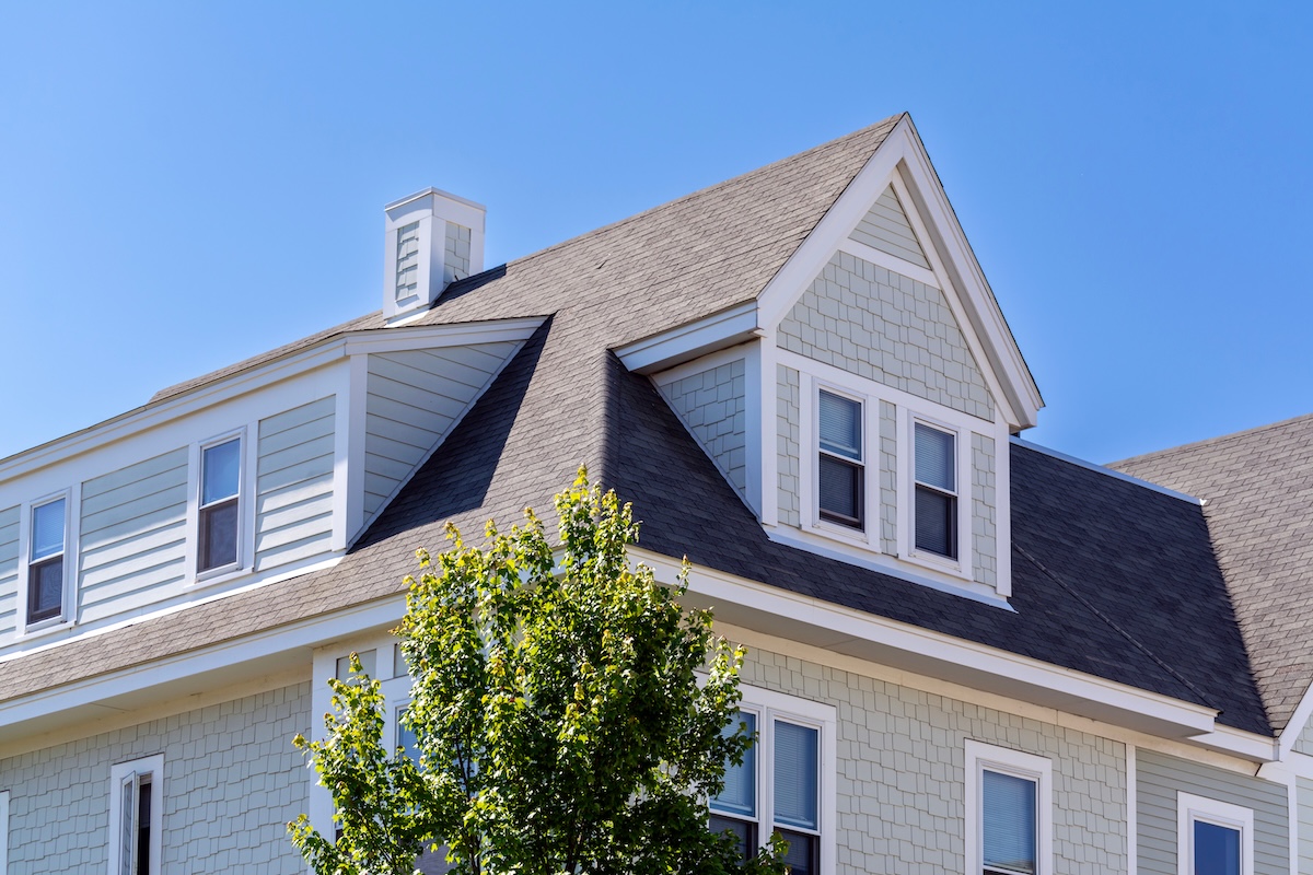 Dormer windows on the sloped shingle roof of a newly built house in Brighton, Massachusetts, USA