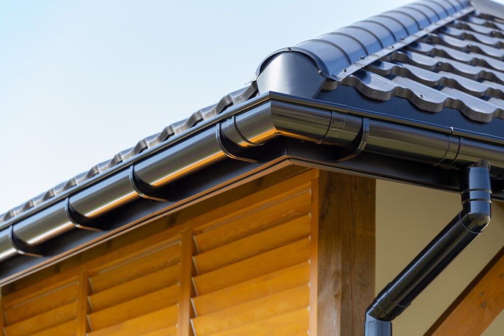 Corner of the new modern house with roof and gutter and wooden shutter