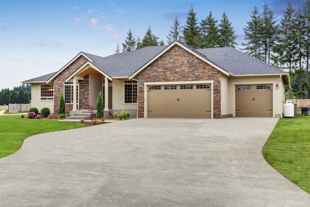 Luxury one level house exterior with brick trim, garage, well kept garden and driveway. Northwest, USA