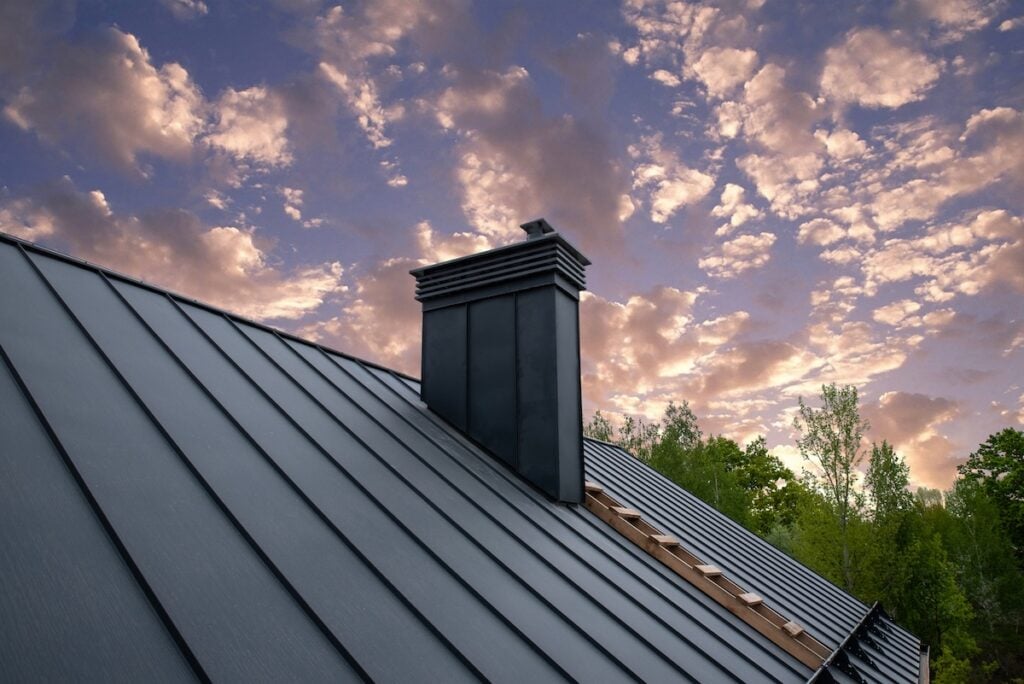 Modern metal chimney on the roof for ventilation how long does a metal roof last