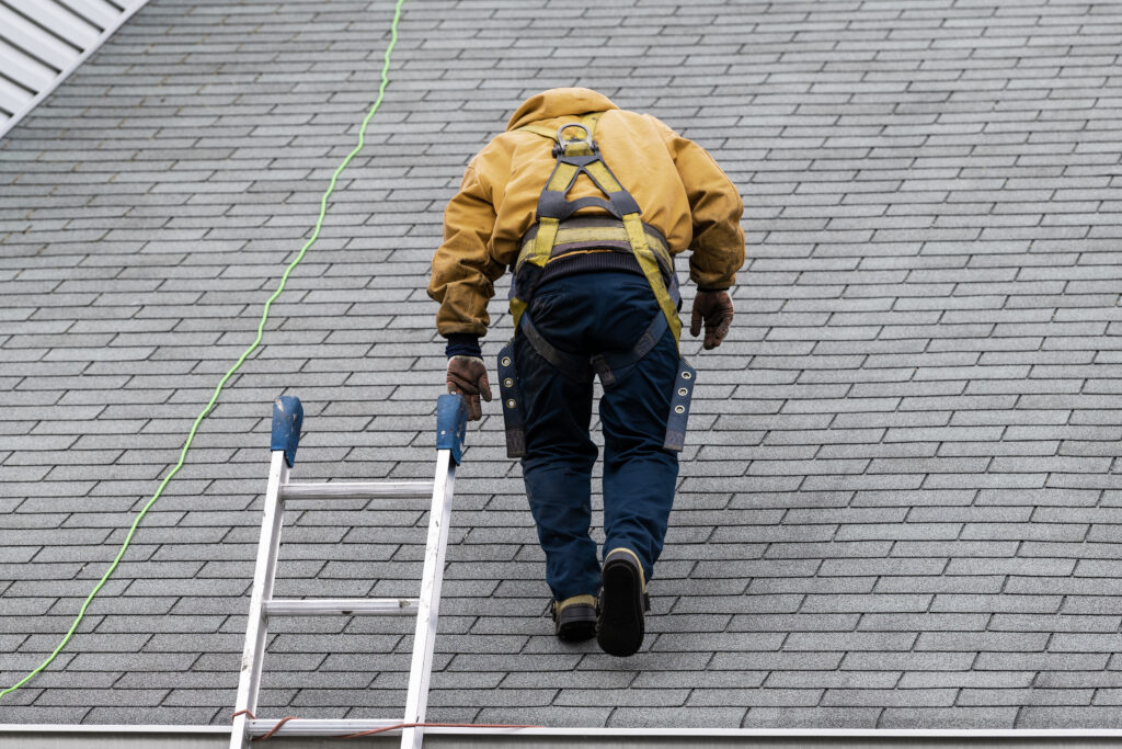 how long does a roof inspection take House during day with gray color Single Family Home and construction man in yellow uniform walking on roof shingles and ladder during repair