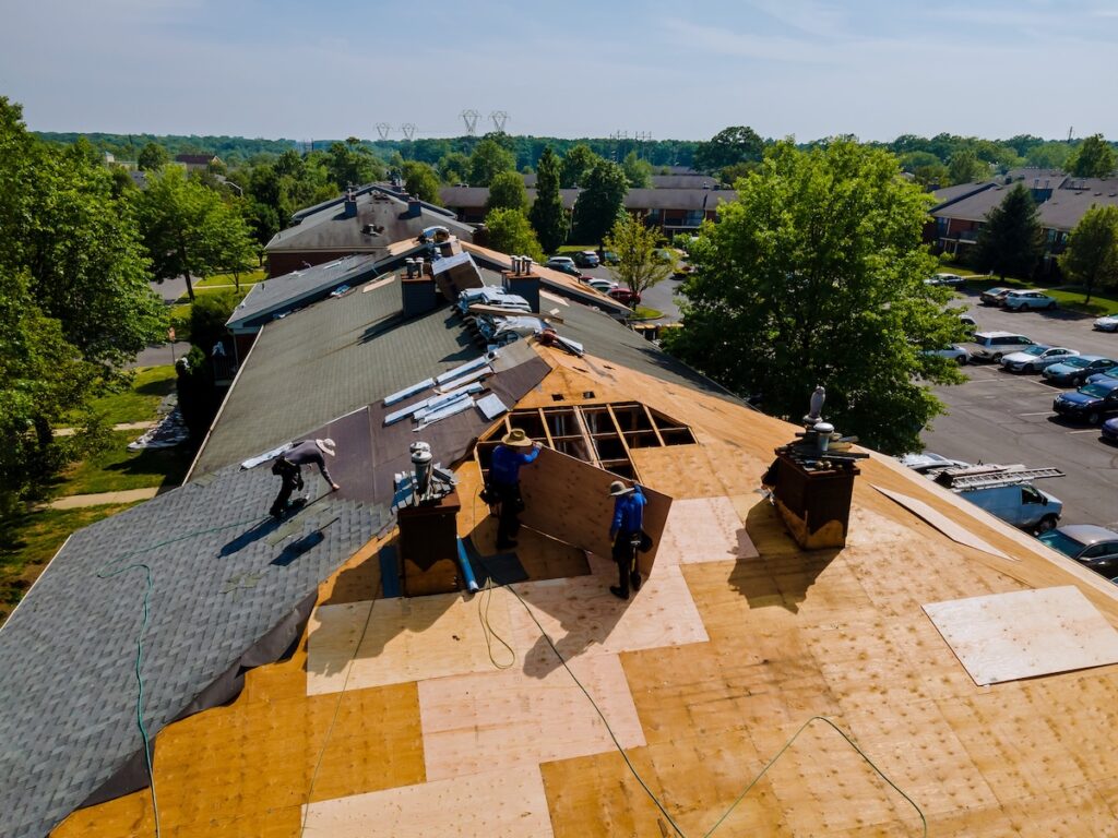 roofing companies holly springs nc Roof shingles need with new shingles of an apartment building replacing a gray asphalt tile