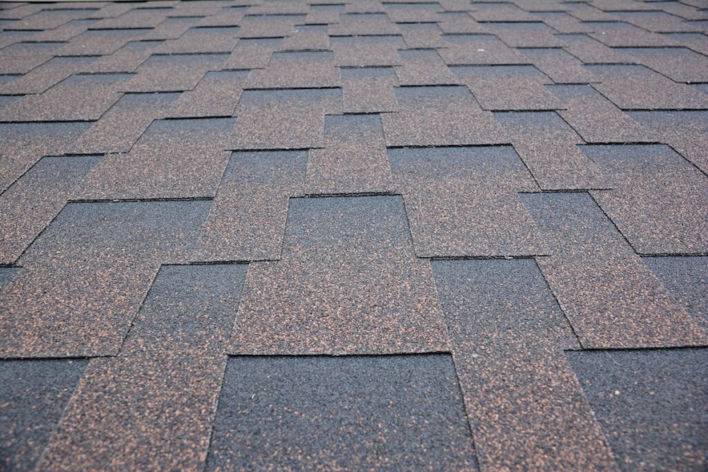 gaf roofing shingles Copper brown roofing asphalt shingles texture background. A close-up of an asphalt laminated, dimensional, or architectural shingled roof. Asphalt shingles roofing construction.