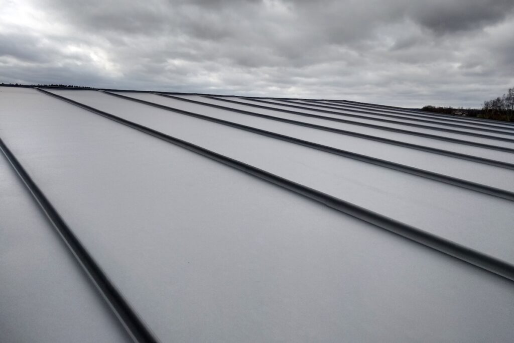 standing seam metal roof Close-up detail of house roof made from gray metal sheets.
