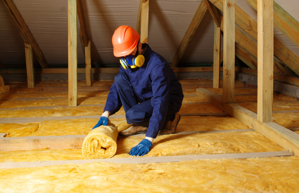 attic insulation Worker insulate the attic with mineral wool