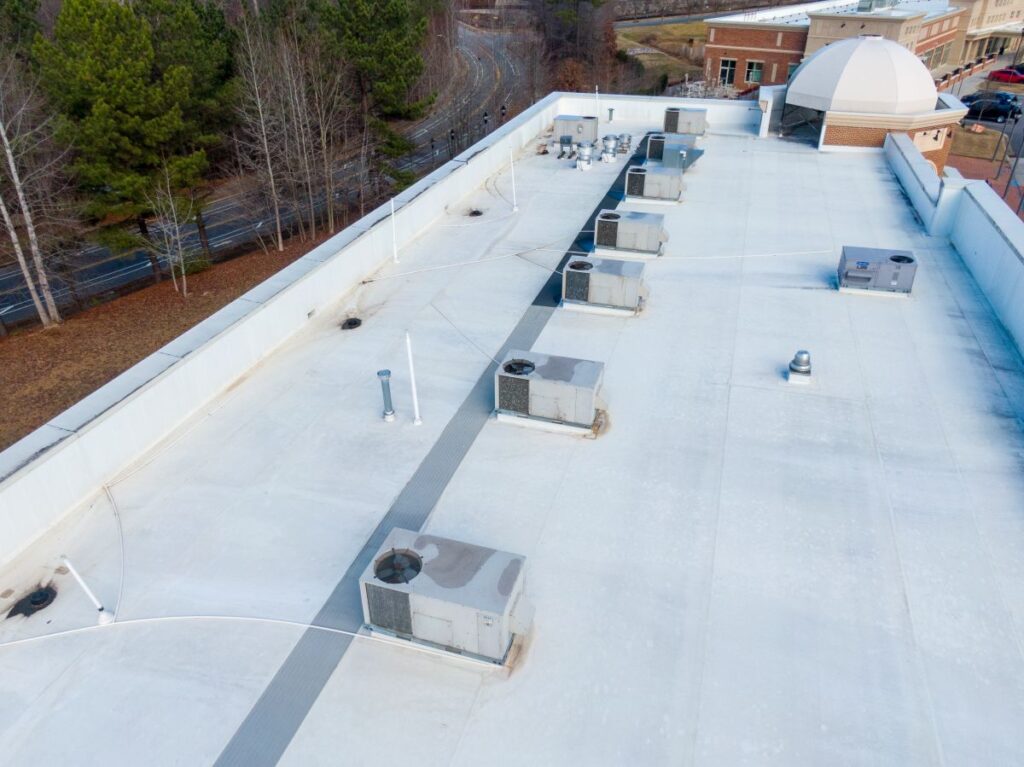 why do commercial buildings have flat roofs white cover