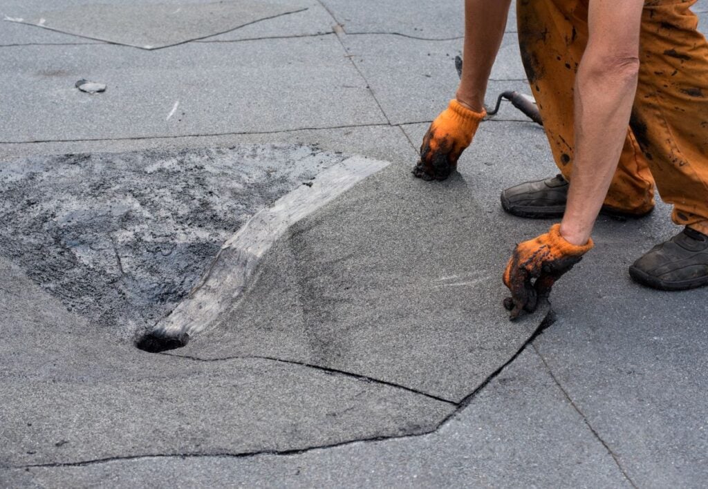 flat roof drainage worker repairing drain
