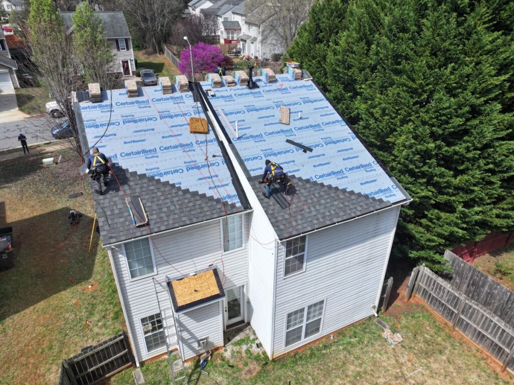 what affordable roof replacement options exist in garner nc aerial view of workers replacing shingles 