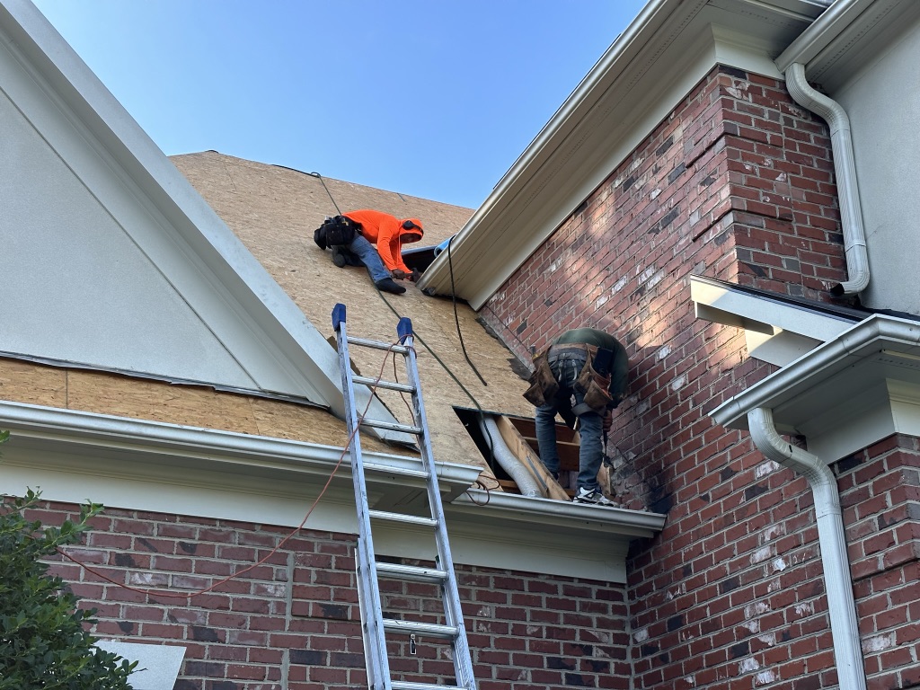 what is the average cost of roof replacement in raleigh nc workers repairing roof