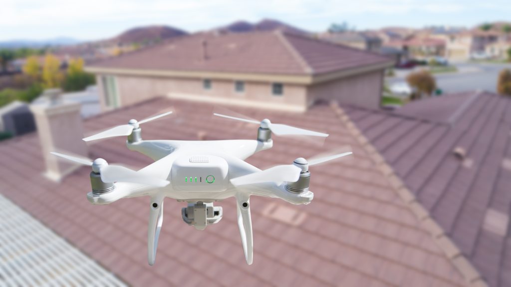 what is included in a full roof replacement in holly springs nc Unmanned Aircraft System (UAV) Quadcopter Drone In The Air Over House Inspecting the Roof.